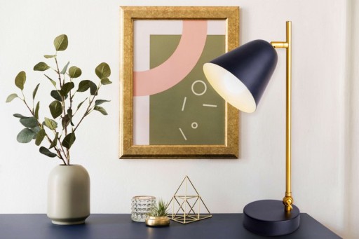 The "Triton" table lamp made of black and brass-colored metal is 42.5 cm high, has an E14 version and is ideal for living room, hallway, office or dessert