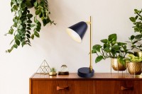 The "Triton" table lamp made of black and brass-colored metal is 42.5 cm high, has an E14 version and is ideal for living room, hallway, office or dessert